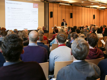 Bild © Johannes Sporrer / Stadt Nürnberg Foto von vielen Personen in einem Raum. Die Personen sitzen auf Stühlen. Vorne hält eine Person einen Vortrag., Bild © Johannes Sporrer / Stadt Nürnberg