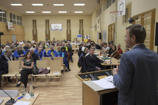 Foto: Der Ober·bürgermeister Marcus König bei einer Bürger·versammlung im Knoblauchs·land.