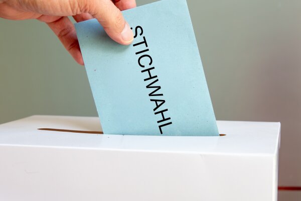 Stichwahl Symbolbild: Briefumschlag mit der Aufschrift Stichwahl und Wahlurne.