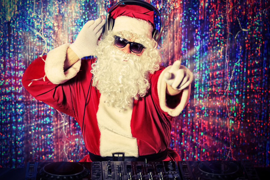 Der DJ als Weihnachtsmann, im Hintergrund ein Vorhang aus buntem Lametta.
