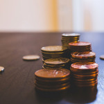 Münzen auf einem dunklen Holztisch