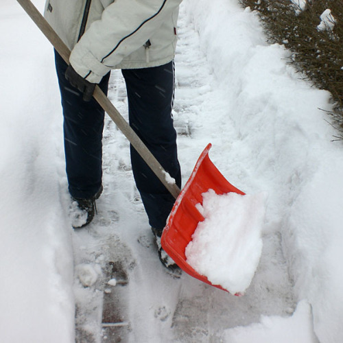 Person schippt mit einer Schneeschaufel den Gehweg frei. © www.aktive-rentner.de / pixelio.de
